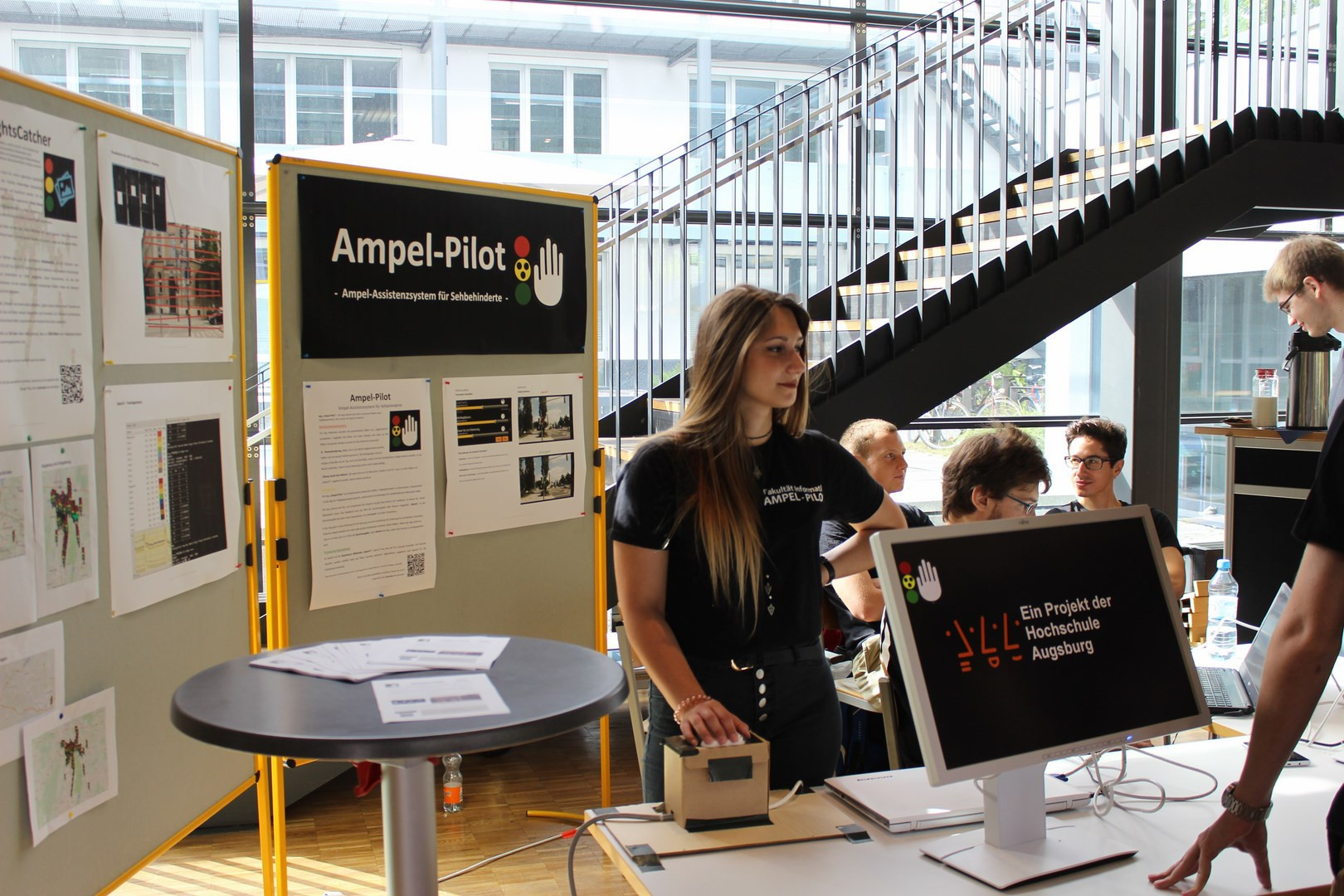 Foto des Projekttags: Eine Studentinn des Projektteams am Stand der Projektgruppe.